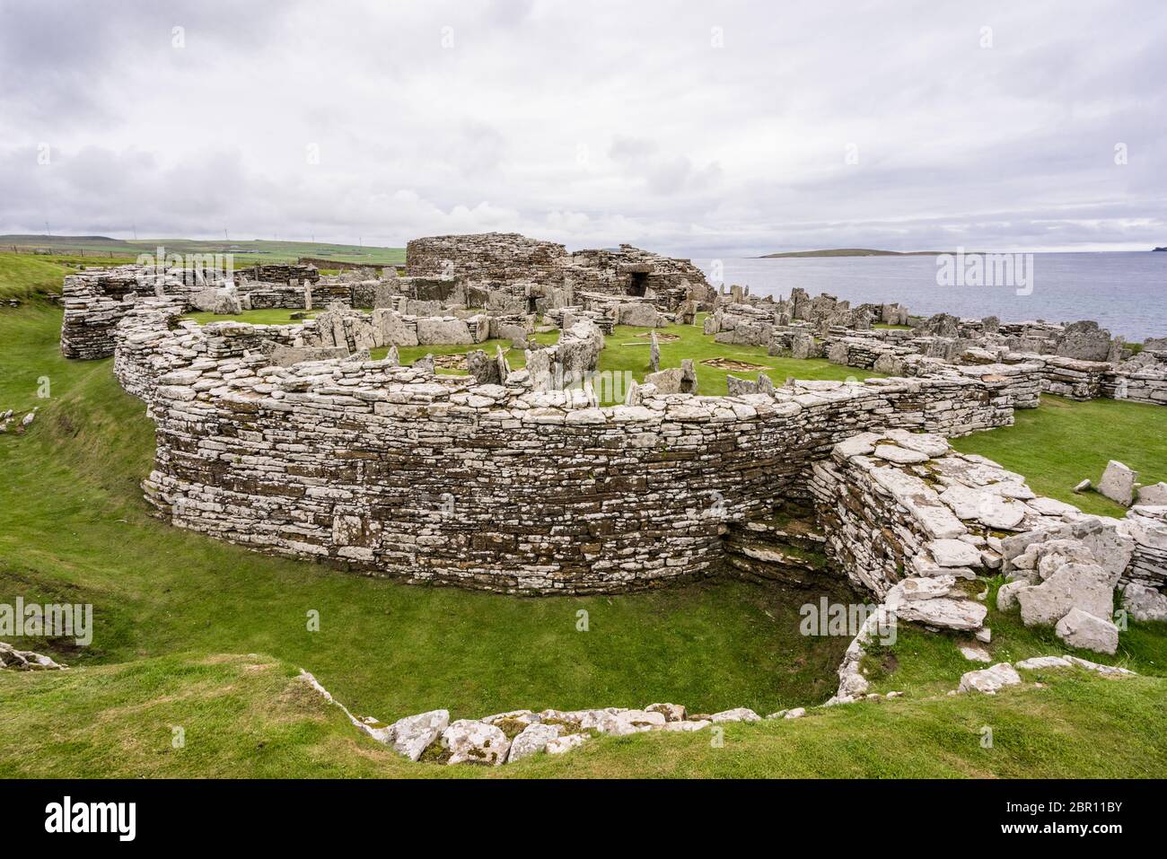 Architettura in pietra preistorica celtica con vista sull'oceano atlantico a Broch of Gurness in Aikerness Bay, Orkney Islands, Scozia Foto Stock