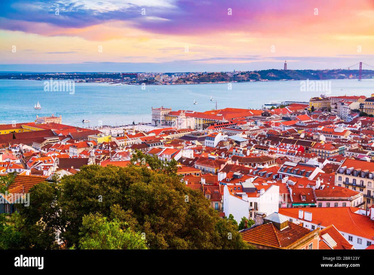 Bellissimo panorama del quartiere della città vecchia di Baixa e del fiume Tago nella città di Lisbona durante il tramonto, visto dalla collina del Castello di Sao Jorge, Portogallo Foto Stock