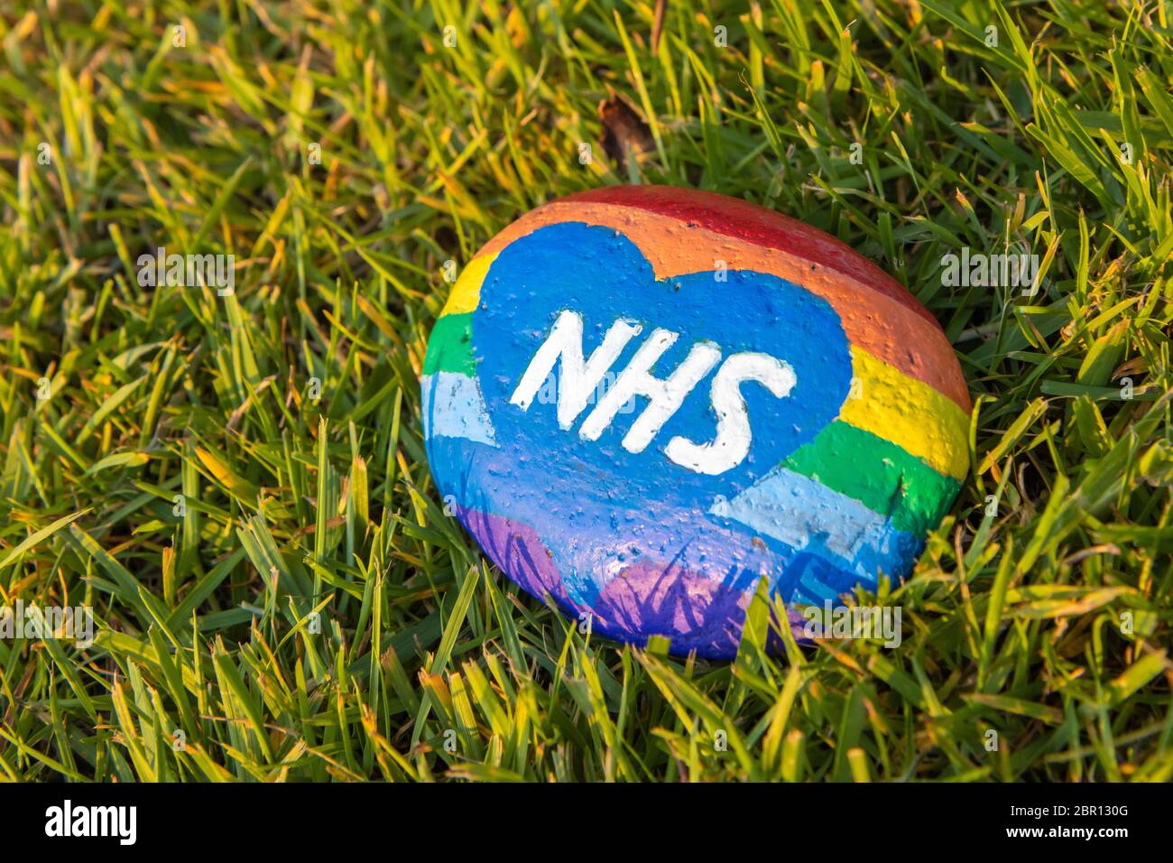 Tributo iridato NHS dipinto su una pietra durante la pandemia di Coronavirus Foto Stock
