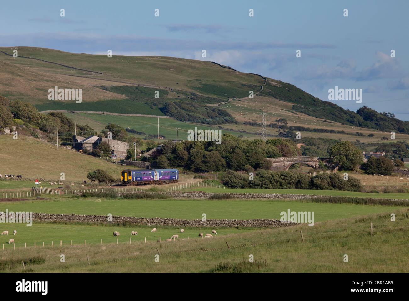 2 treni a carrello singolo della classe 153 della ferrovia nord che attraversano la campagna a Silecroft sulla linea ferroviaria panoramica della costa Cumbriana Foto Stock