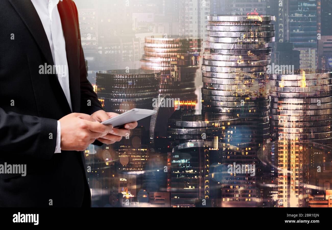 Doppia esposizione di successo businessmanusing tablet analisi dei dati su moneta e città background.Time per il business. Tempo di affari, finanza, investimento Foto Stock
