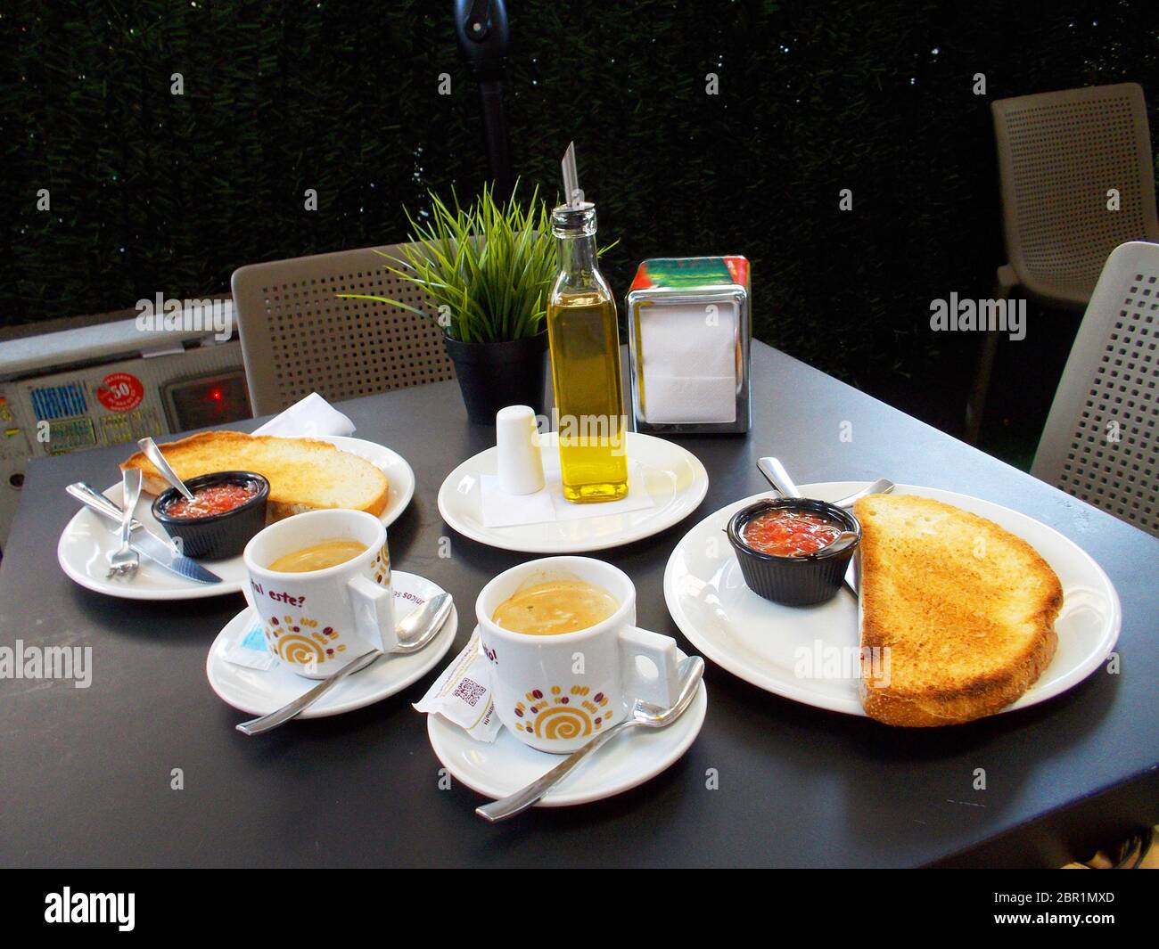 Colazione spagnola: Tazze di caffè, olio d'oliva, pomodoro e toast. Spagna. Foto Stock