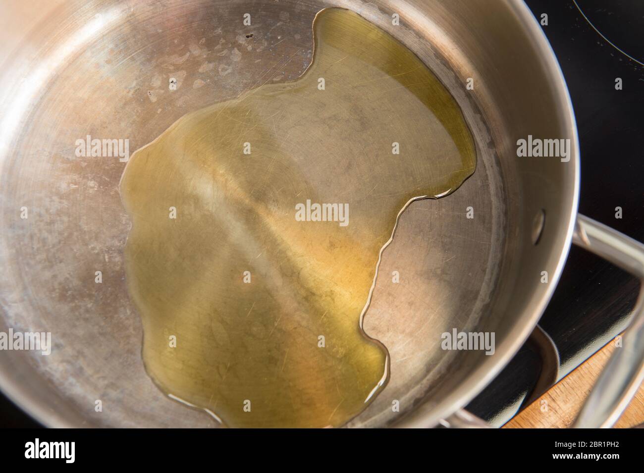 Preparazione della ricetta spagnola della Paella, una delle sequenze di 18 immagini. Olio d'oliva aggiunto alla padella Foto Stock