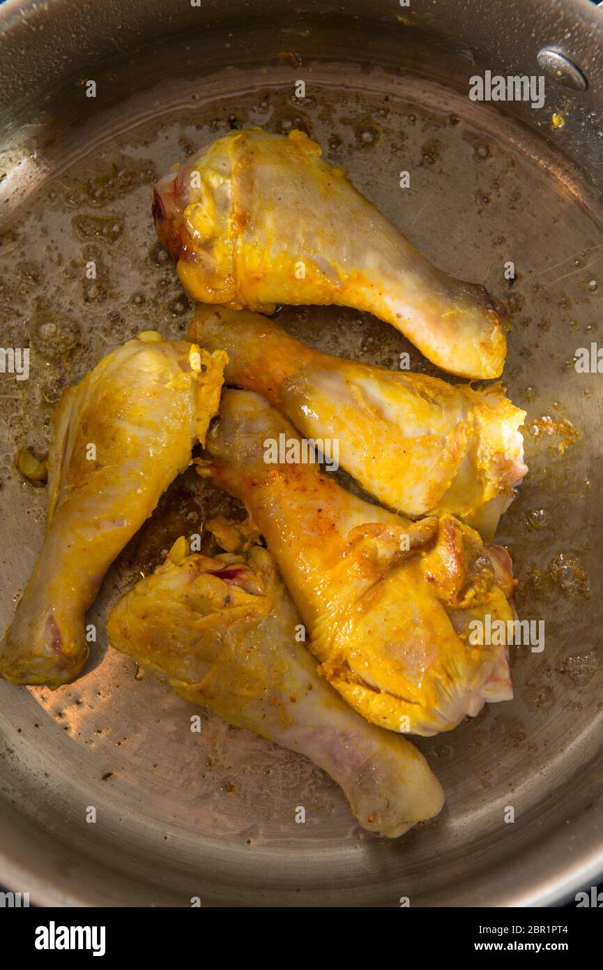 Preparazione della ricetta spagnola della Paella, una delle sequenze di 18 immagini. Cosce di pollo dorate in una padella saltata Foto Stock