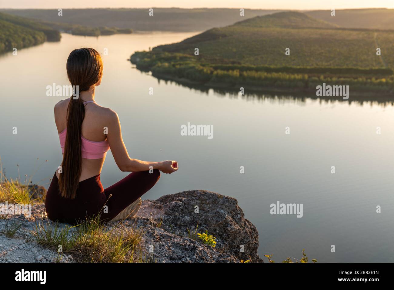 Ragazza dello sport che fa yoga in montagna bellissimo paesaggio. La giovane donna conduce uno stile di vita sano, medita Foto Stock