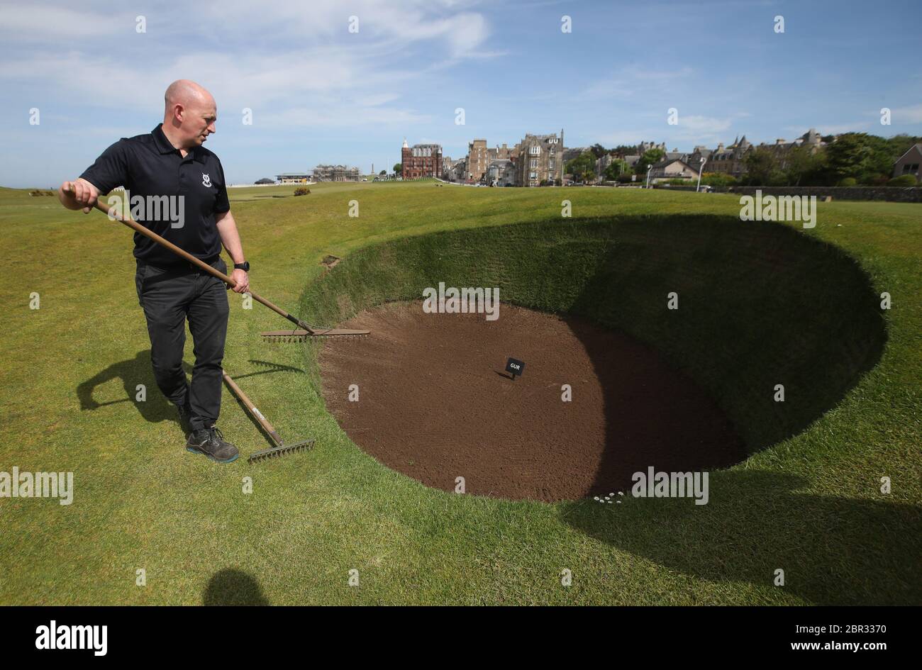 Direttore di Green Keeping a St Andrews Links Trust Sandy Reid rastrella il bunker Road Hole al 17esimo verde sul vecchio corso a St Andrews. Il primo ministro Nicola Sturgeon annuncerà una "mappa delle rotte" per il sollevamento del blocco del coronavirus in Scozia giovedì Foto Stock