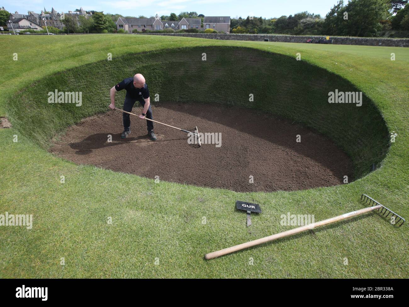 Direttore di Green Keeping a St Andrews Links Trust Sandy Reid rastrella il bunker Road Hole al 17esimo verde sul vecchio corso a St Andrews. Il primo ministro Nicola Sturgeon annuncerà una "mappa delle rotte" per il sollevamento del blocco del coronavirus in Scozia giovedì Foto Stock