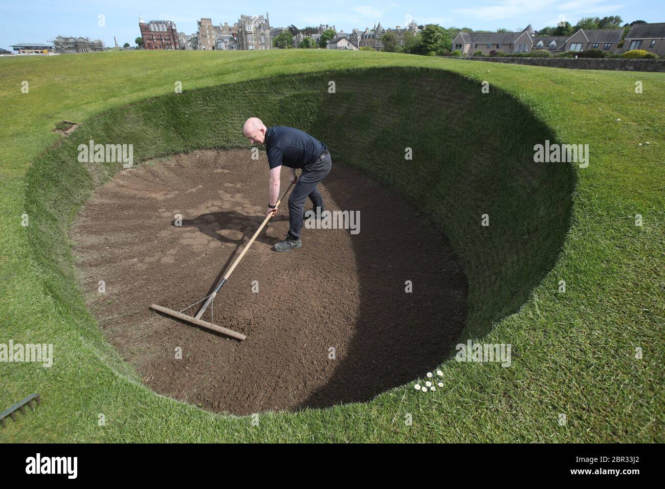 Direttore di Green Keeping a St Andrews Links Trust Sandy Reid rastrella il bunker Road Hole al 17esimo verde sul vecchio corso a St Andrews. Il primo ministro Nicola Sturgeon annuncerà una "mappa delle rotte" per il sollevamento del blocco del coronavirus in Scozia giovedì Foto Stock