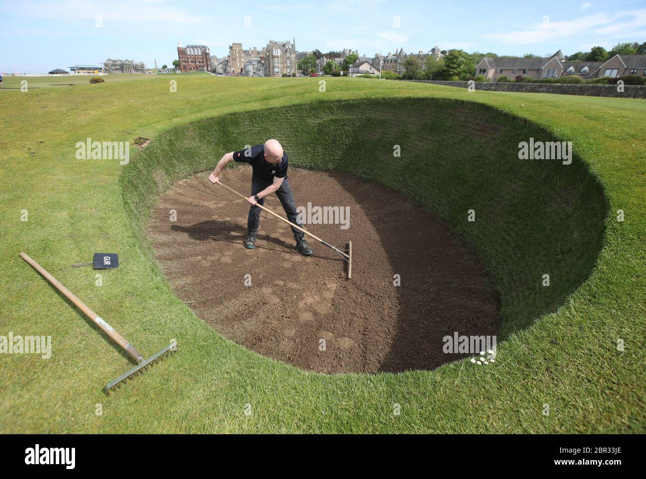 Direttore di Green Keeping a St Andrews Links Trust Sandy Reid rastrella il bunker Road Hole al 17esimo verde sul vecchio corso a St Andrews. Il primo ministro Nicola Sturgeon annuncerà una "mappa delle rotte" per il sollevamento del blocco del coronavirus in Scozia giovedì Foto Stock