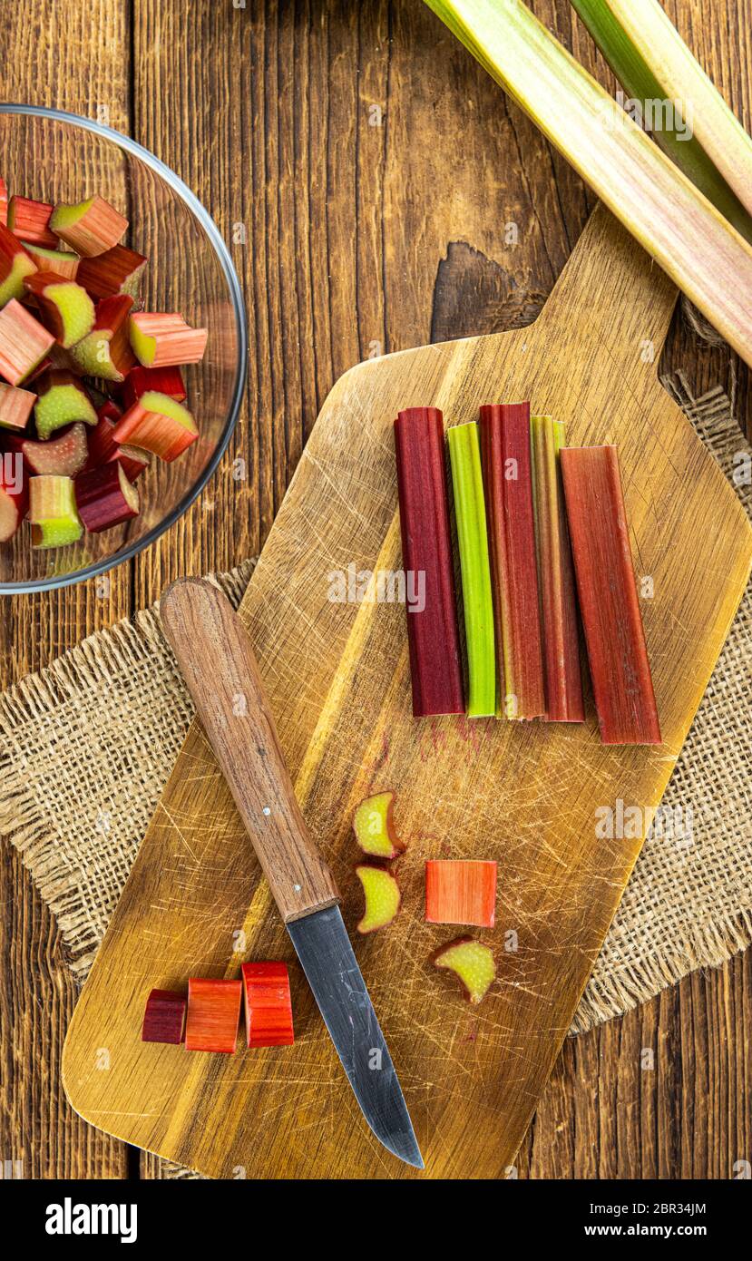 Rabarbaro tritato su un vecchio tavolo di legno (colpo di primo piano; fuoco selettivo) Foto Stock