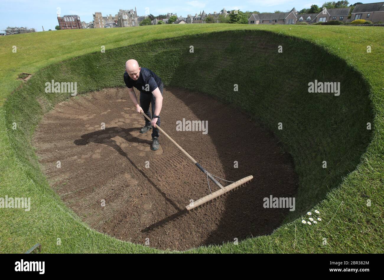 Direttore di Green Keeping a St Andrews Links Trust Sandy Reid rastrella il bunker Road Hole al 17esimo verde sul vecchio corso a St Andrews. Il primo ministro Nicola Sturgeon annuncerà una "mappa delle rotte" per il sollevamento del blocco del coronavirus in Scozia giovedì Foto Stock
