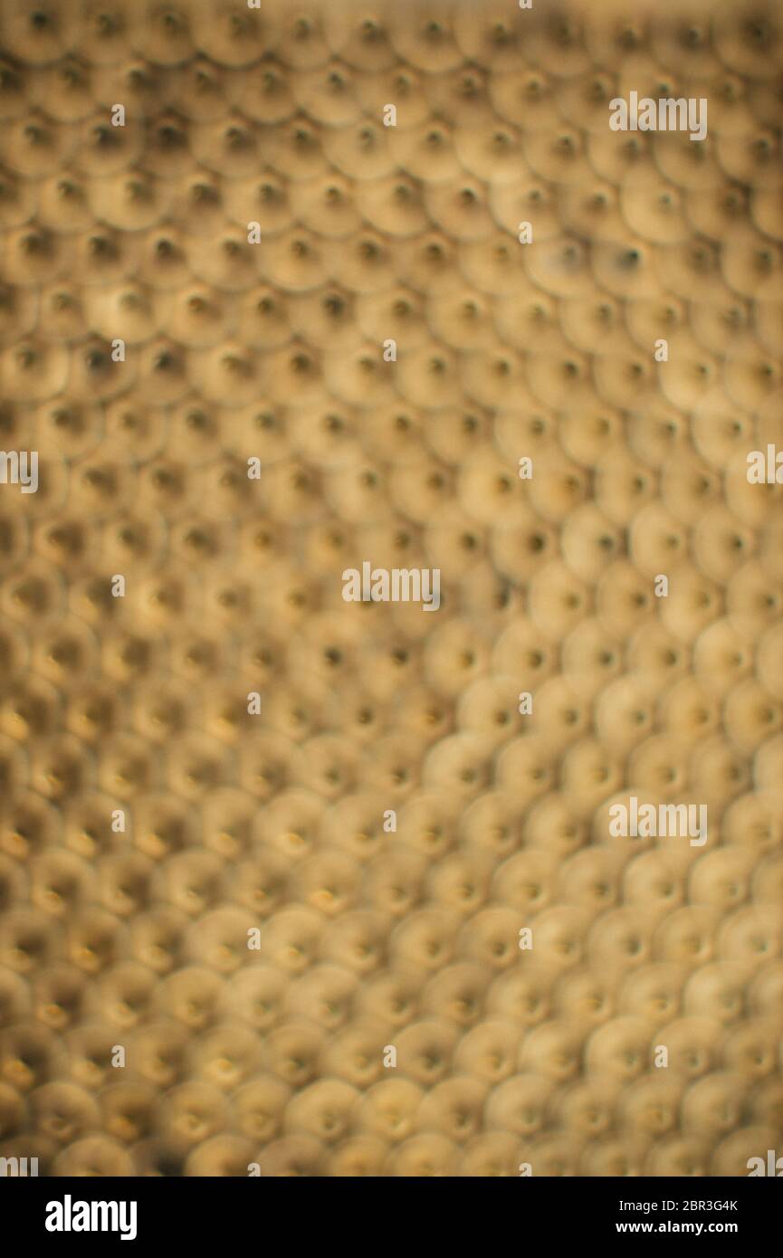 Primo piano, macro. Vecchi dadi di ottone sovietico. Struttura, fondo di noci di ottone disposte in forma di nido d'ape. Dadi di colore oro. Dadi sporchi nell'olio. B Foto Stock
