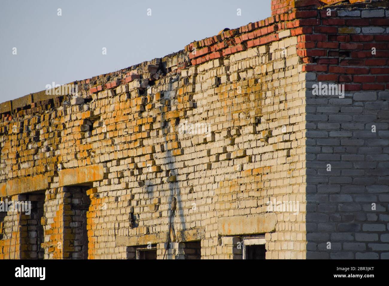 Vecchio mattone sovietica edificio abbandonato. Collassare costruzione in mattoni. Il bianco e il rosso mattone Foto Stock