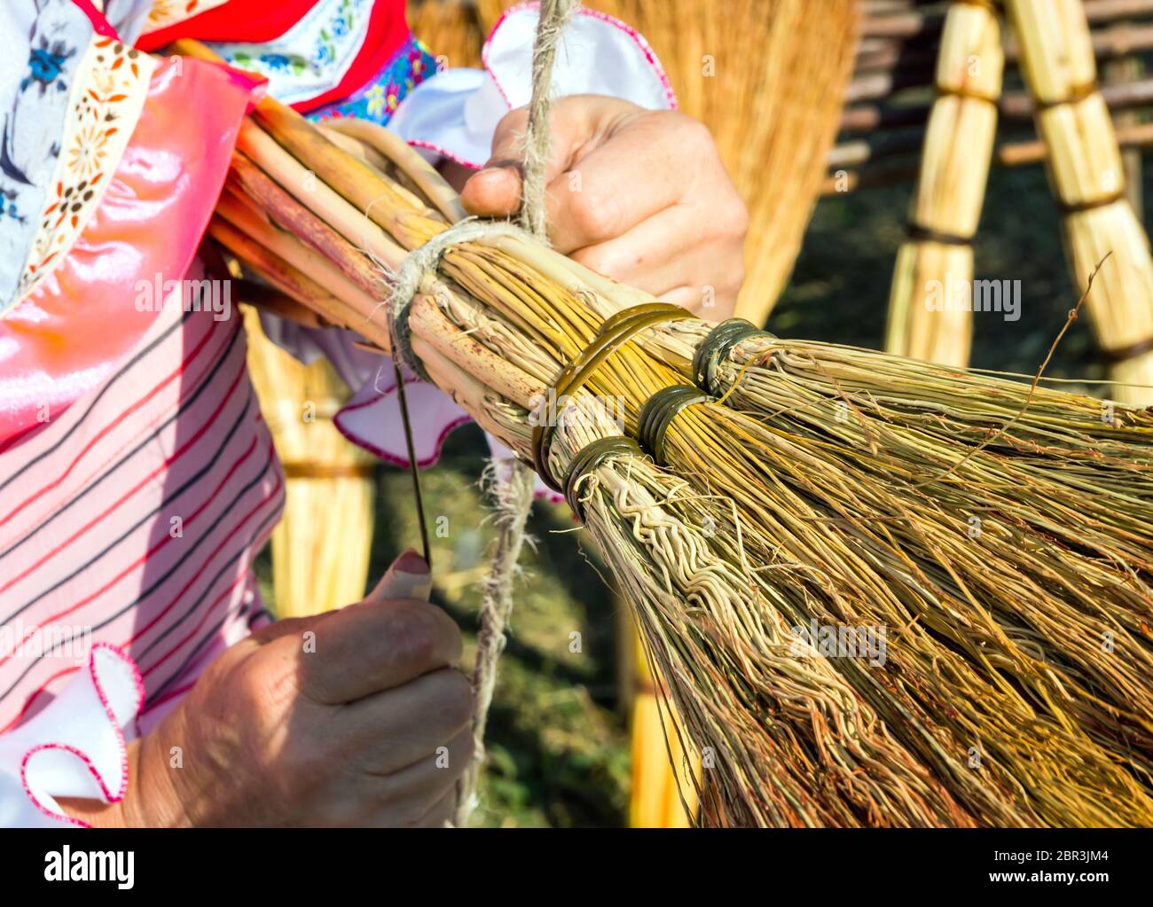 Fare una scopa domestica dai rami del sorgo Foto Stock