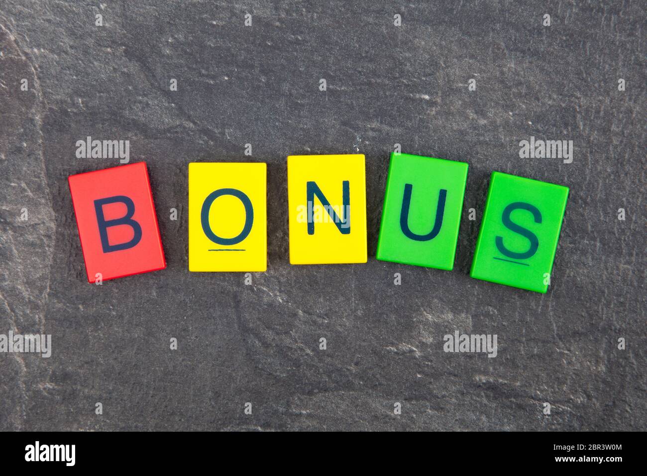 Concetto di Bonus - plastica colorata lettere su sfondo scuro Foto Stock