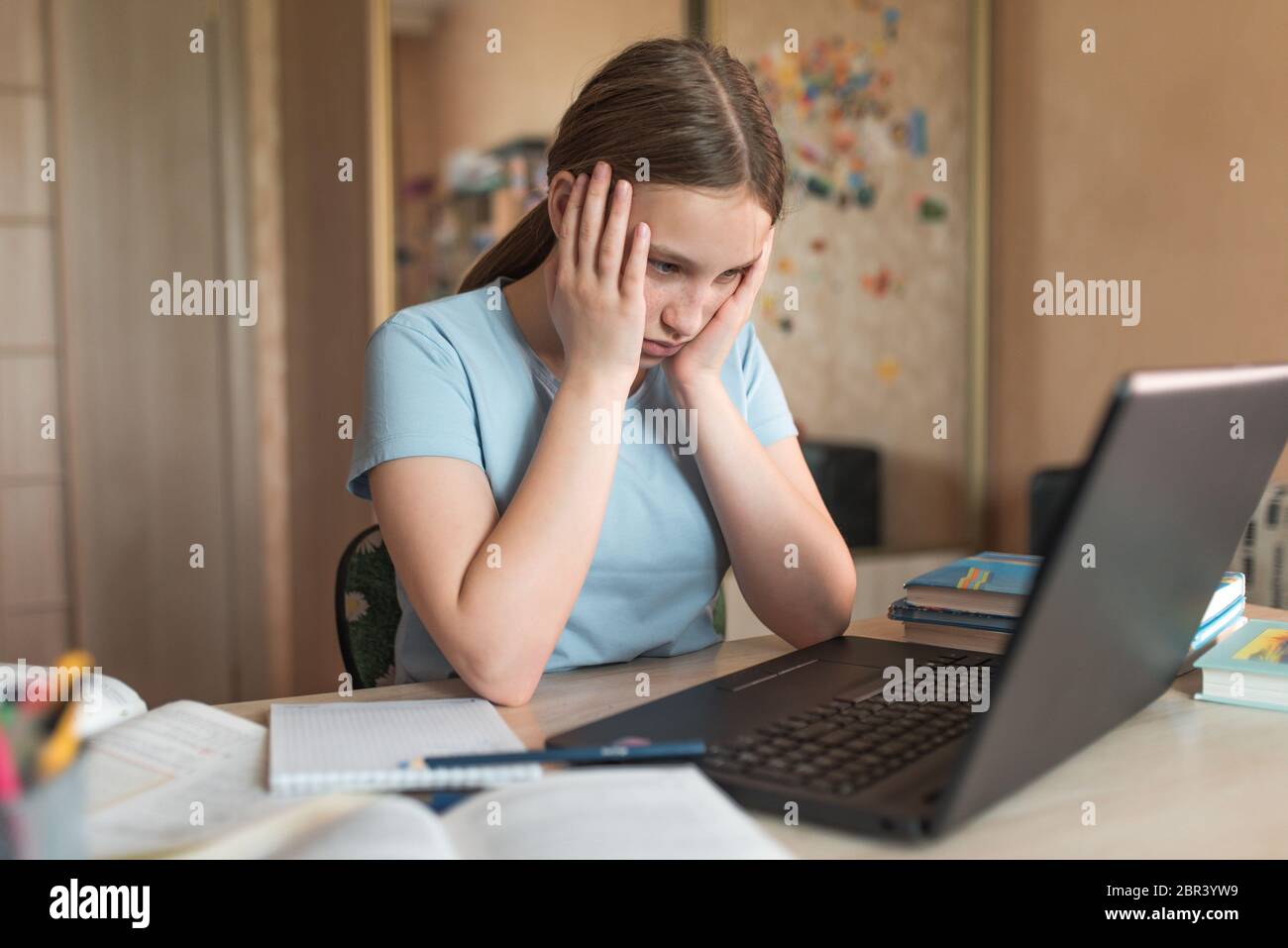 Stanco sconvolto ragazza adolescente 12-14 anni, casa, laptop lezioni, guardare video di lettura assegnazioni. E-Education a distanza apprendimento video Internet Foto Stock