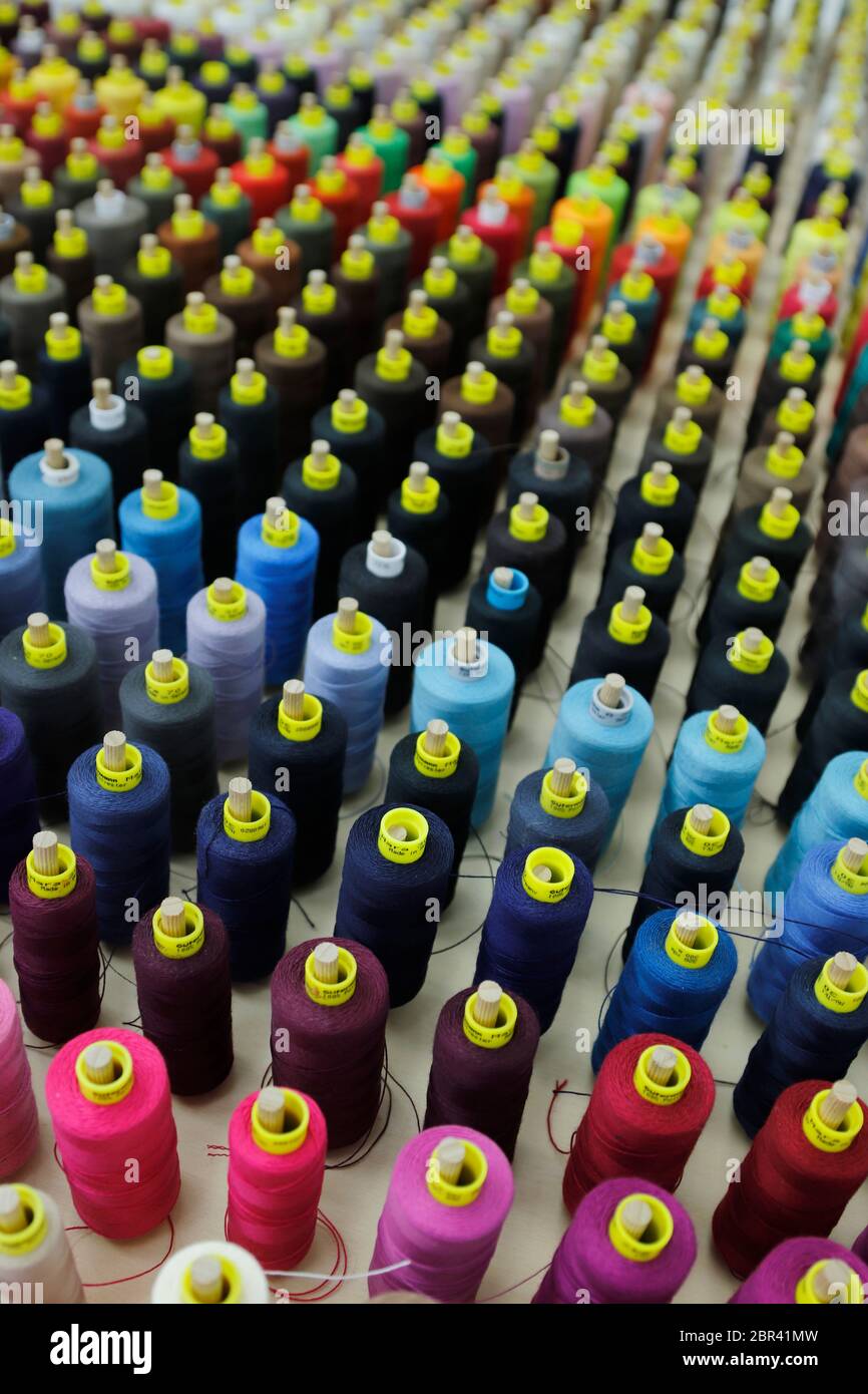 Assortimento di bobine filettate colorate in un'azienda italiana di alta couture Foto Stock
