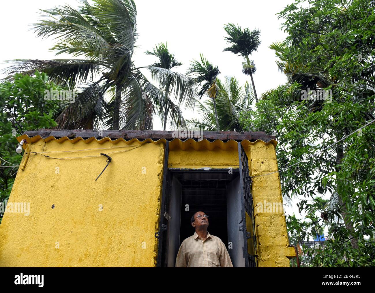 Un vecchio uomo è visto guardando in su al cielo dalla sua porta prima del colpo del ciclone Amphan.Super Cyclone Amphan colpisce Bengala occidentale & Kolkata con una velocità di 130 km / h il pomeriggio del 20 maggio. Foto Stock