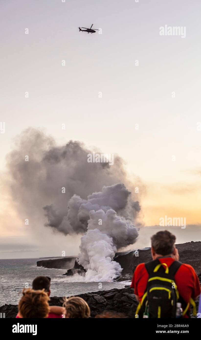 I turisti che guardano e scattano foto di lava che scorre nell'oceano Pacifico dalla zona di Rift orientale a Puna, Hawaii, USA. 6 Aprile 2017. Foto Stock