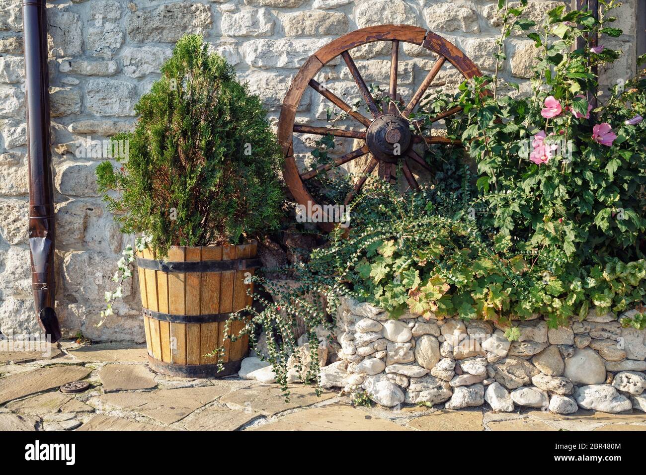 Ancora in vita all'aperto con un appoggiate e una vasca di legno con una thuja. Foto Stock