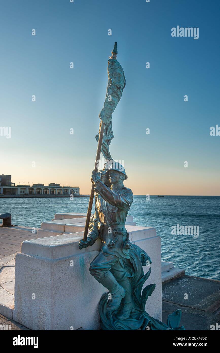 La statua di Bersagliere a trieste di fronte alla piazza dell'`unità. Bronzo di statua soldato di Bersagliere con bandiera a Trieste, vicino a unita d'Italia Foto Stock