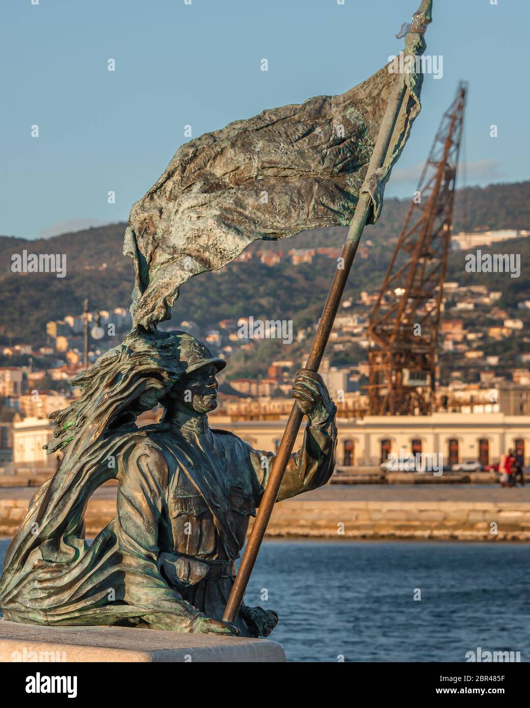La statua di Bersagliere a trieste di fronte alla piazza dell'`unità. Bronzo di statua soldato di Bersagliere con bandiera a Trieste, vicino a unita d'Italia Foto Stock