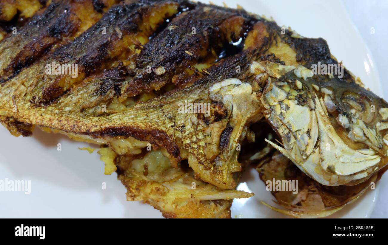 Primo piano di un pesce fritto fusilier, servito su un piatto. Foto Stock