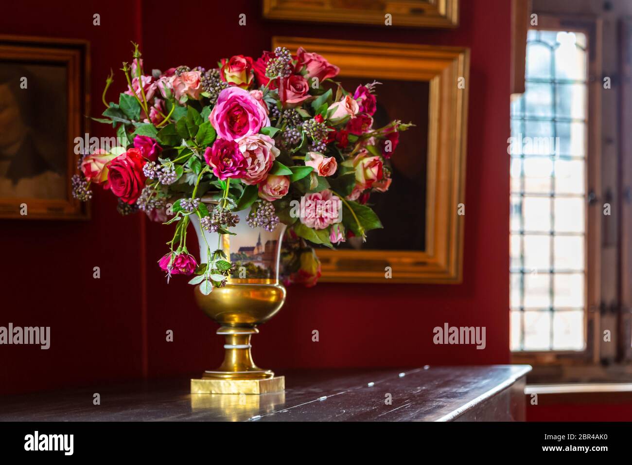 Vaso con un bellissimo mazzo di fiori freschi di fiori all'interno di un antico palazzo. Bouquet di fiori in un vaso di porcellana in stile vintage. Renaissa Foto Stock