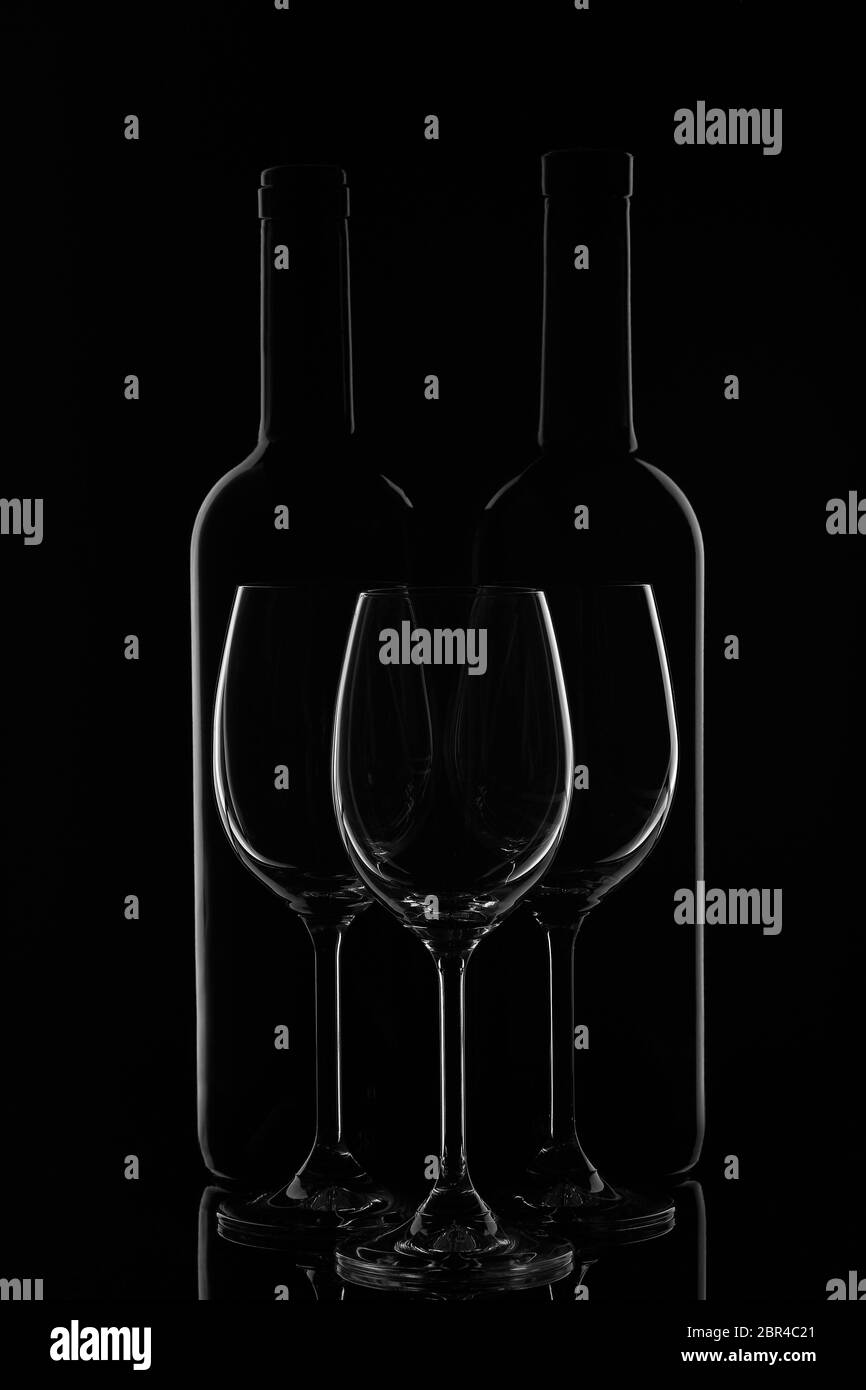 Silhouette di due bottiglie di vino e tre vini vuoti su fondo nero con riflessi. Contorno con gradiente e evidenziazioni Foto Stock