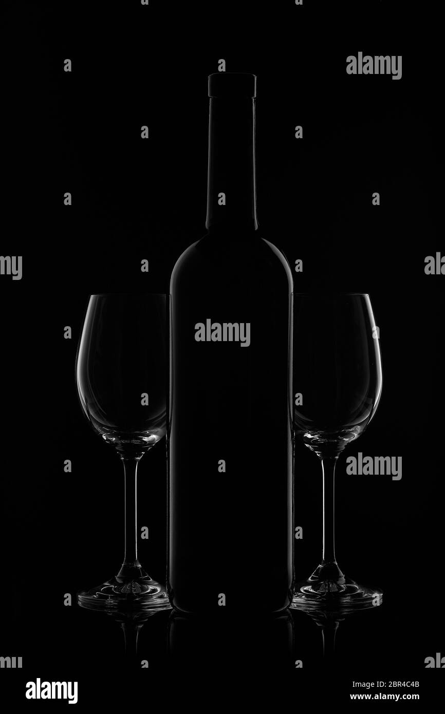 Silhouette di bottiglia di vino e due verricelli vuoti su fondo nero con riflessi. Contorno con gradiente e evidenziazioni Foto Stock