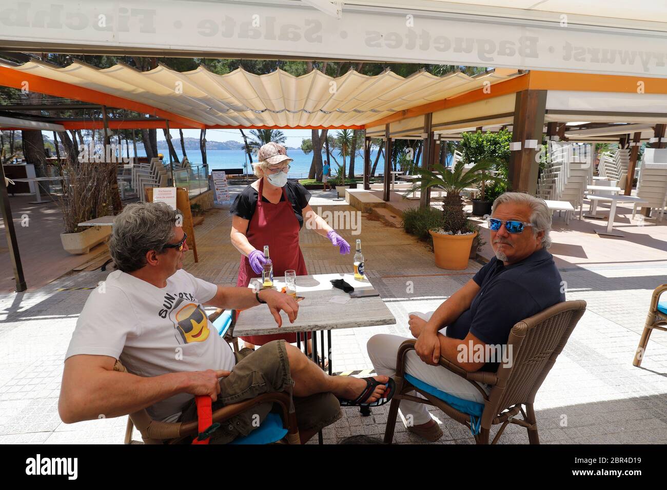 Calvia, Spagna. 20 Maggio 2020. Michael dalla Germania (l) e Ivo dai Paesi Bassi bere una birra sulla terrazza del ristorante Esbar sulla spiaggia di Paguera sull'isola spagnola di Maiorca. La spiaggia di Paguera sull'isola spagnola di Maiorca è vuota. Alcune province spagnole sono autorizzate ad allentare le prime restrizioni in una prima fase dallo scoppio del coronavirus (COVID-19). Credit: Clara Margais/dpa/Alamy Live News Foto Stock