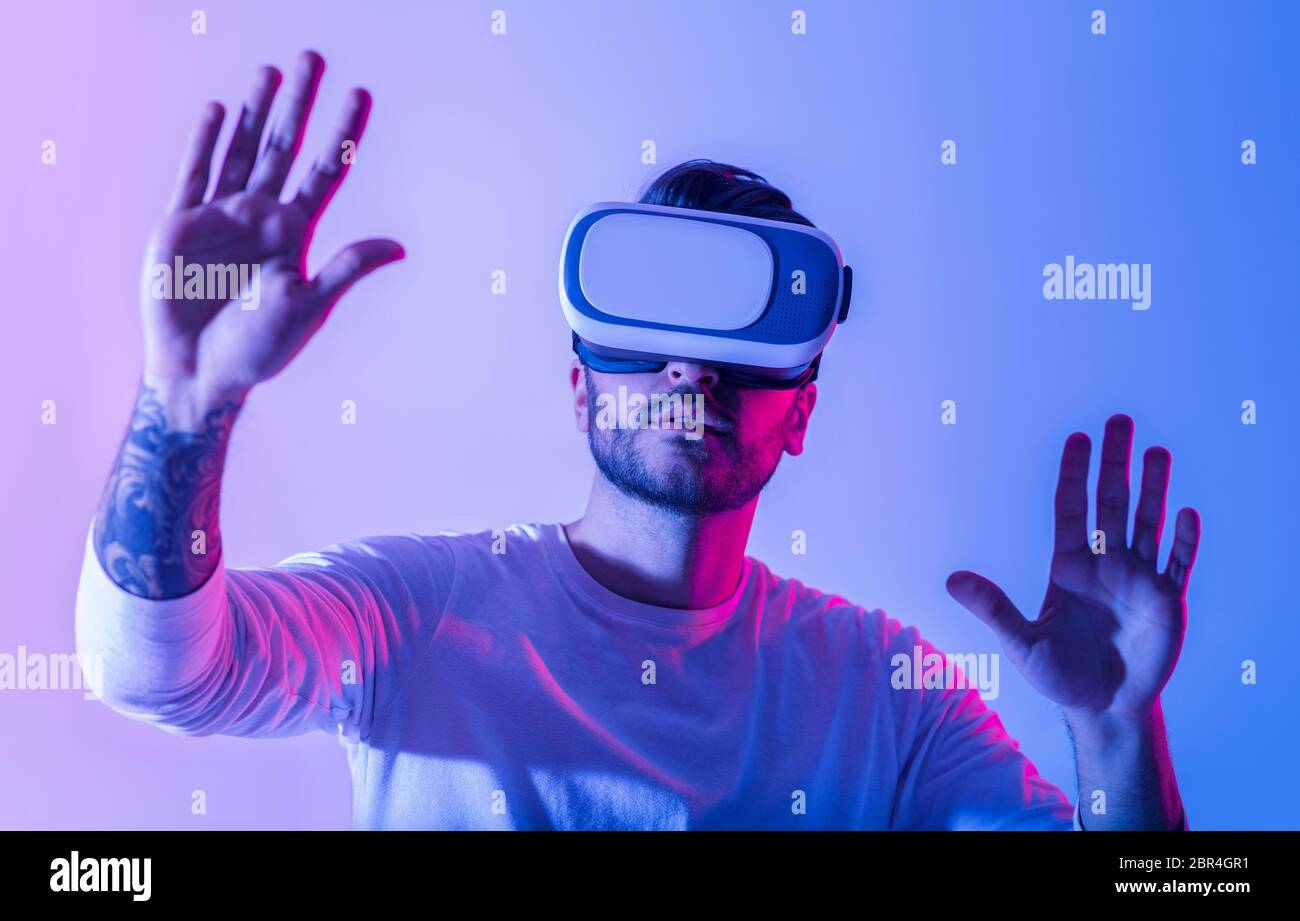 Uomo millenario in realtà virtuale con senso di immersione in ambiente virtuale Foto Stock