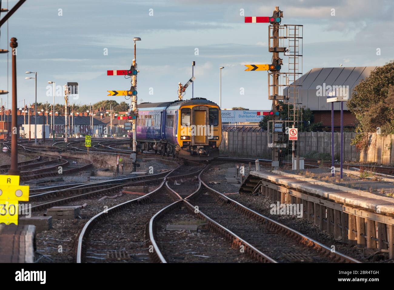 Treno sprinter classe 156 della Northern Rail in arrivo alla stazione ferroviaria di Blackpool North con i segnali meccanici di casa e di ferrovia distante Foto Stock