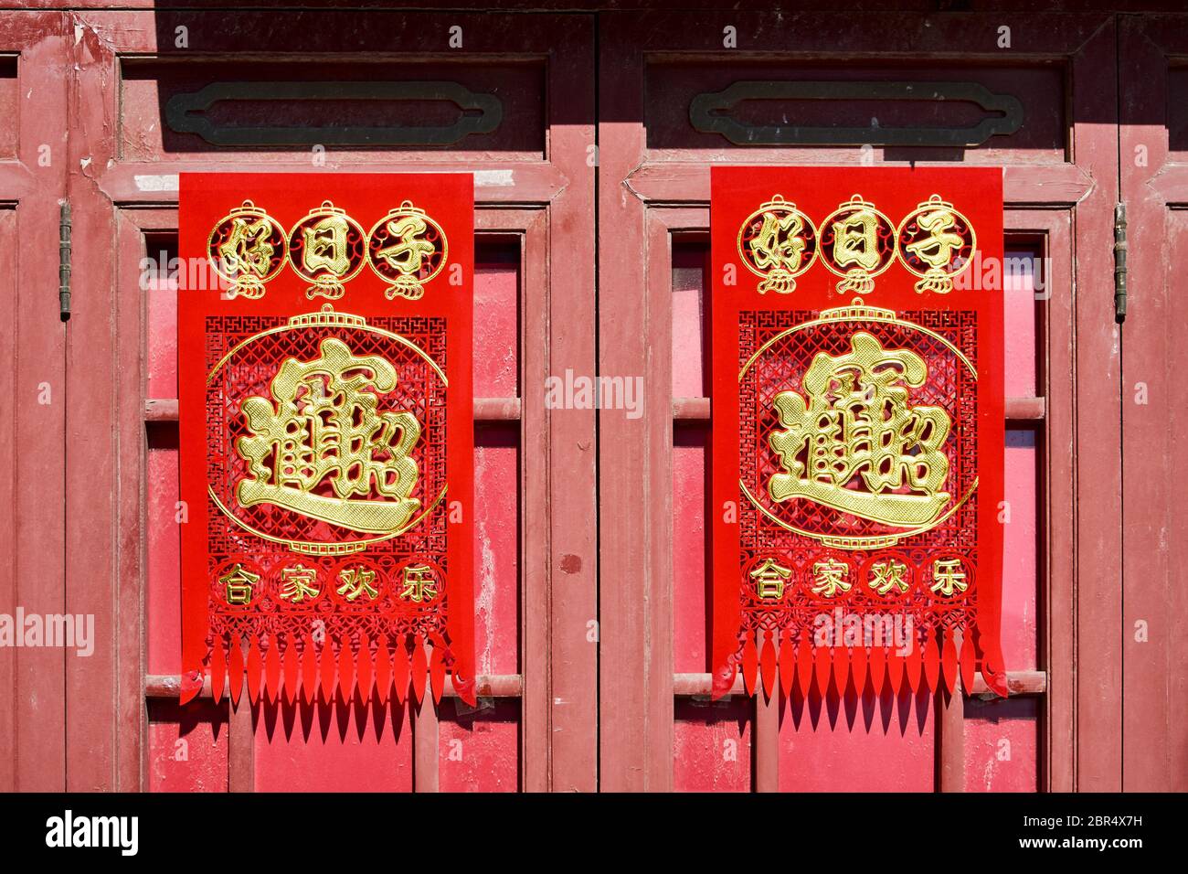 Pechino / Cina - 14 febbraio 2016: Porta vecchia nel tradizionale vicolo hutong di Pechino, decorata con caratteri cinesi durante il Capodanno cinese celebrati Foto Stock