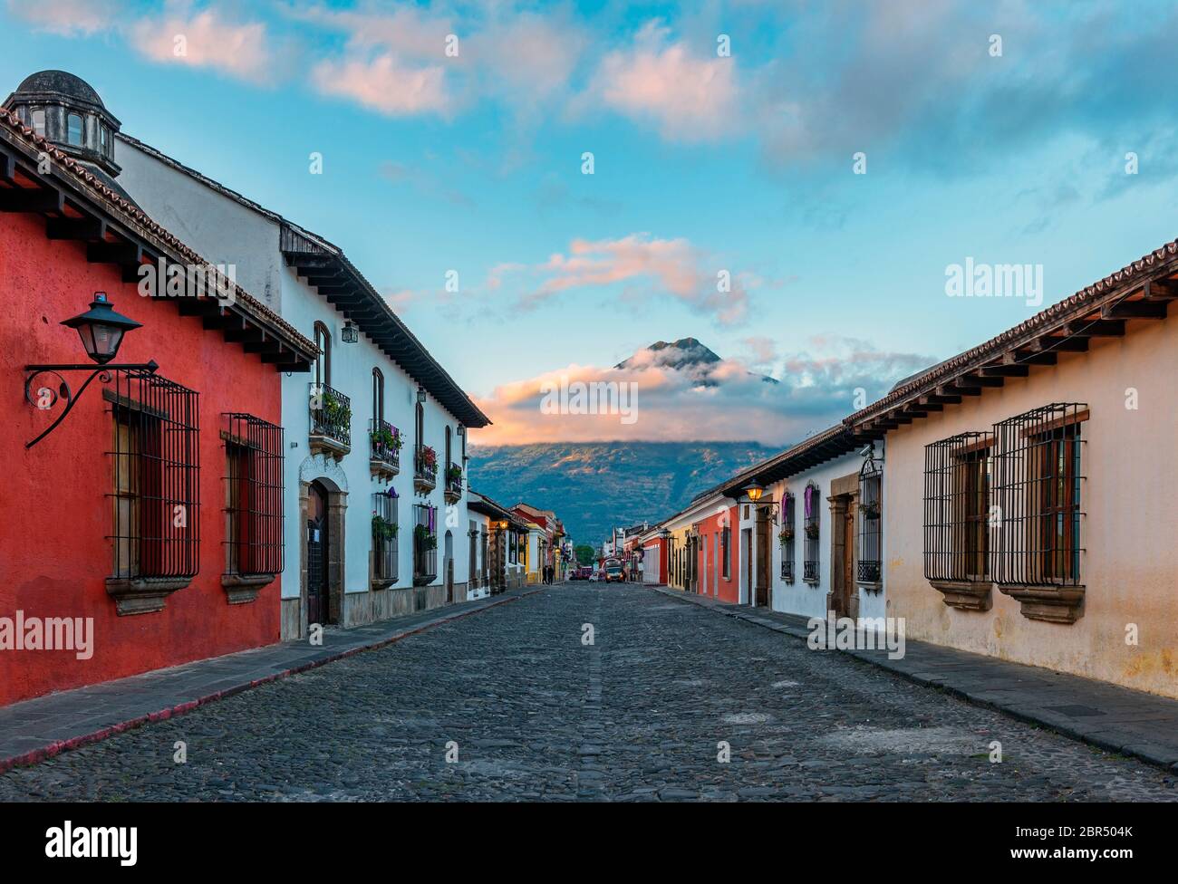 Alba in una strada in stile coloniale di Antigua City con il vulcano Agua sullo sfondo, Guatemala. Foto Stock