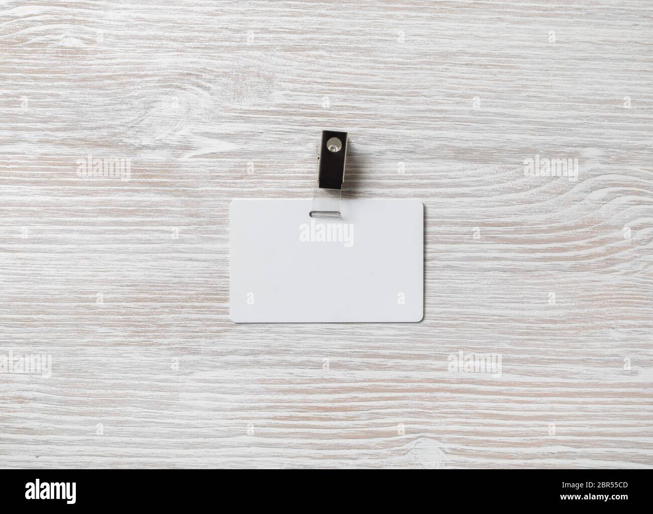 Vuoto badge in plastica mockup sulla luce sullo sfondo di legno. White id card. Spazio per il testo.Flat laici. Foto Stock