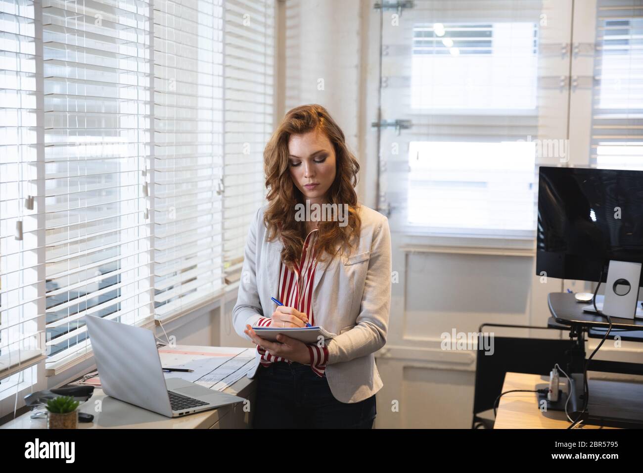Caucasica donna d'affari che lavora in un ufficio moderno casual Foto Stock