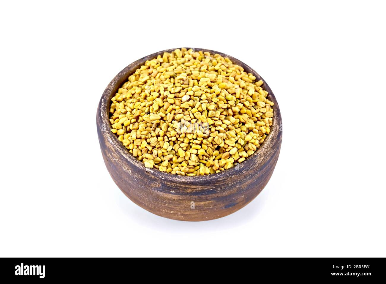 Fieno greco semi in una argilla marrone recipiente isolato su sfondo bianco Foto Stock