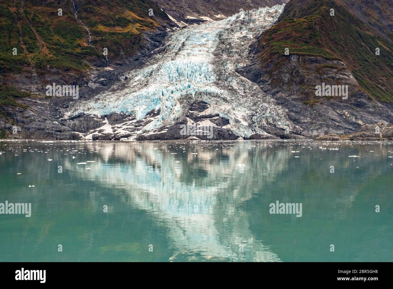 Cascata ghiacciaio riflesso nelle acque di Barry Arm nel fiordo Harriman, Prince William Sound vicino a Whittier, Alaska. Foto Stock