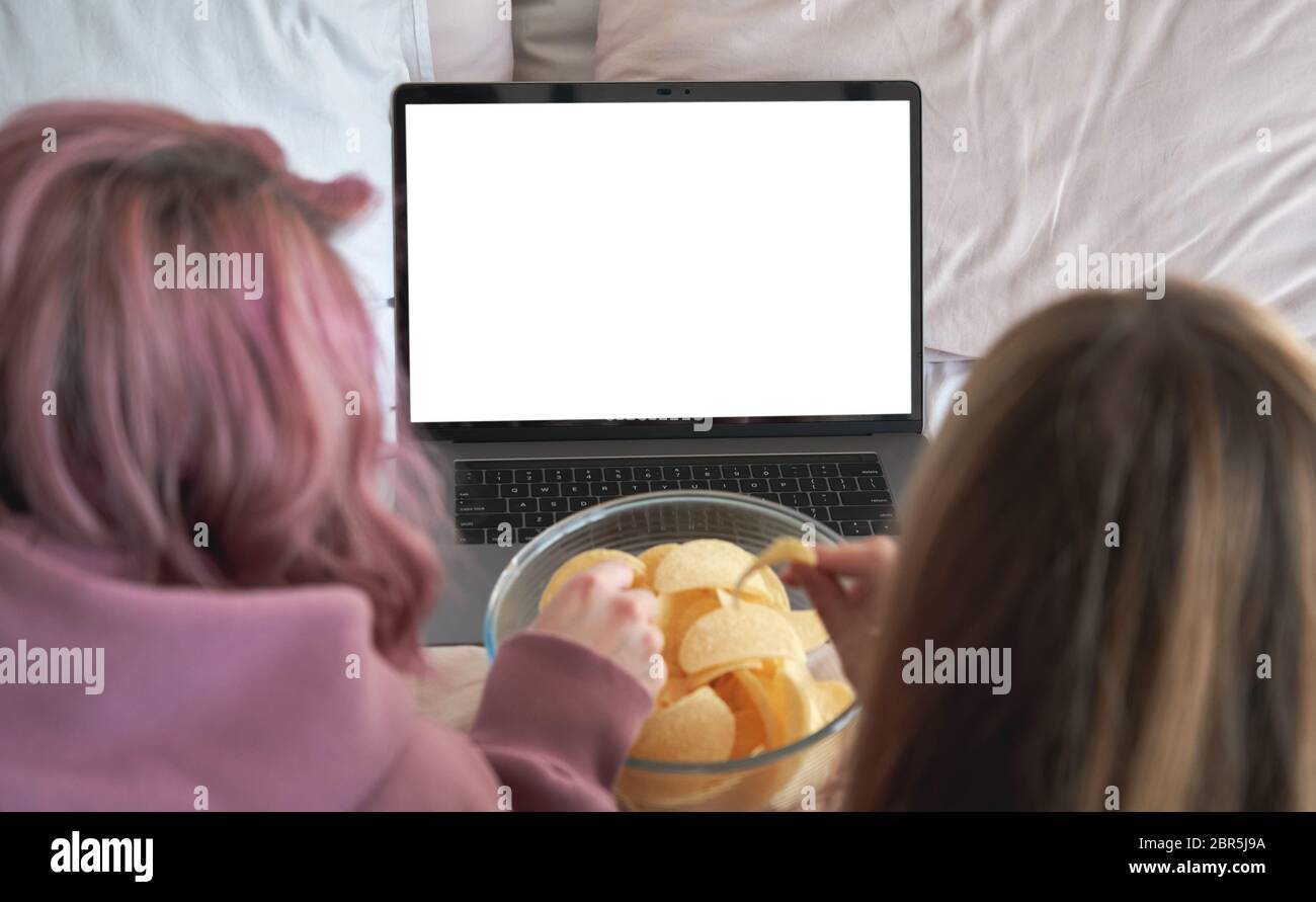 Due ragazze teen amici guardare serie di film tv online su computer portatile mock up schermo. Foto Stock