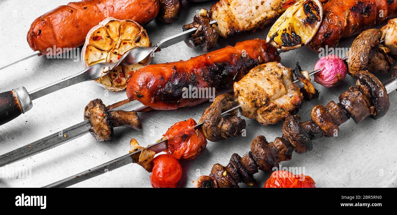 Assortimento di piatti alla griglia, spiedini, salsicce e verdure grigliate Foto Stock