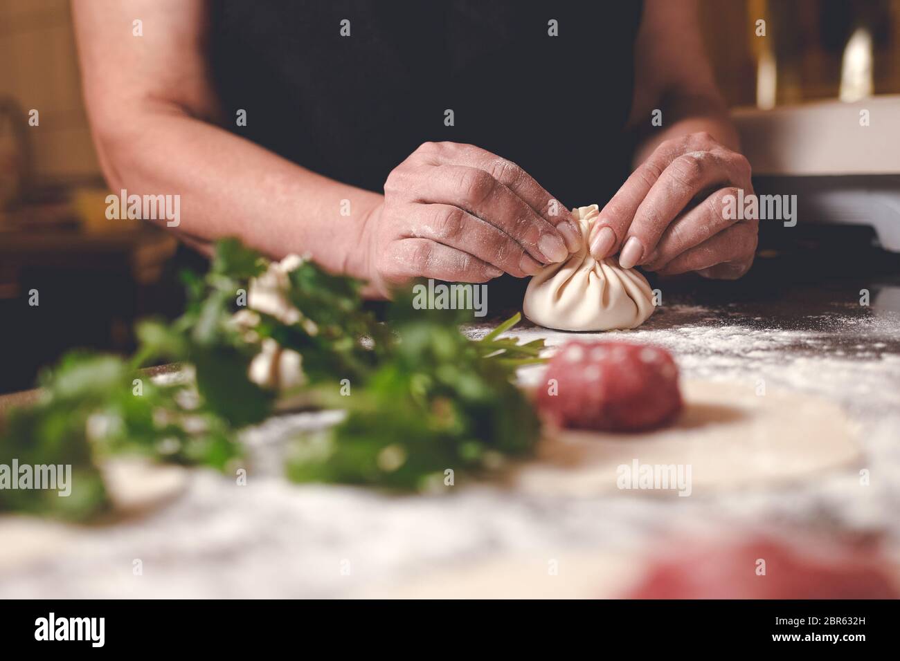 Chef di un ristorante georgiano sculpts khinkali. Processo di cottura Khinkali Foto Stock