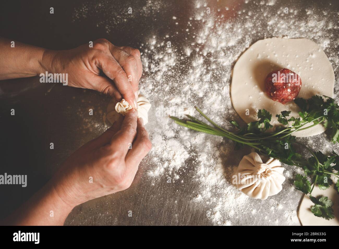 Il cuoco scolpisce il khinkali secondo la ricetta originale georgiana Foto Stock