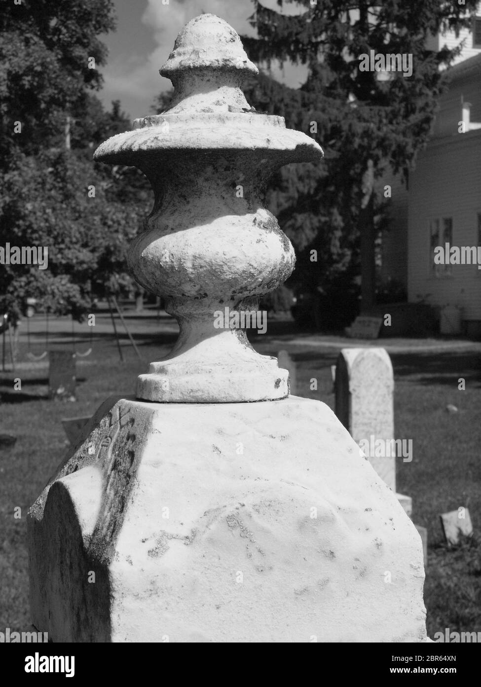 Antico cimitero in bianco e nero risalente al 1800. Mostrando negligenza e usura, alcune pietre sono sull'orlo di cadere. Foto Stock