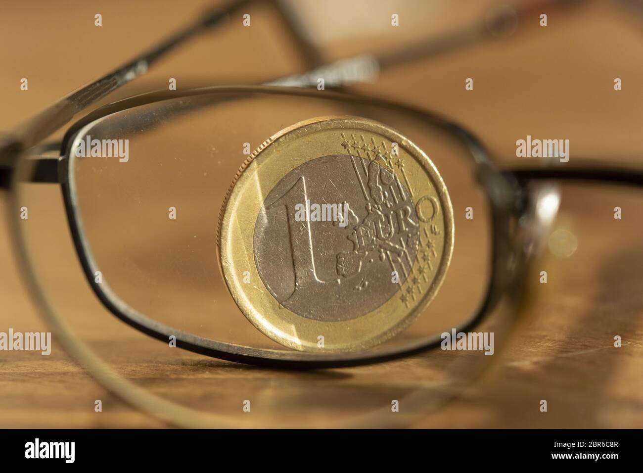 Concetto di risparmio accorta con un euro fotografato attraverso una coppia di specs Foto Stock