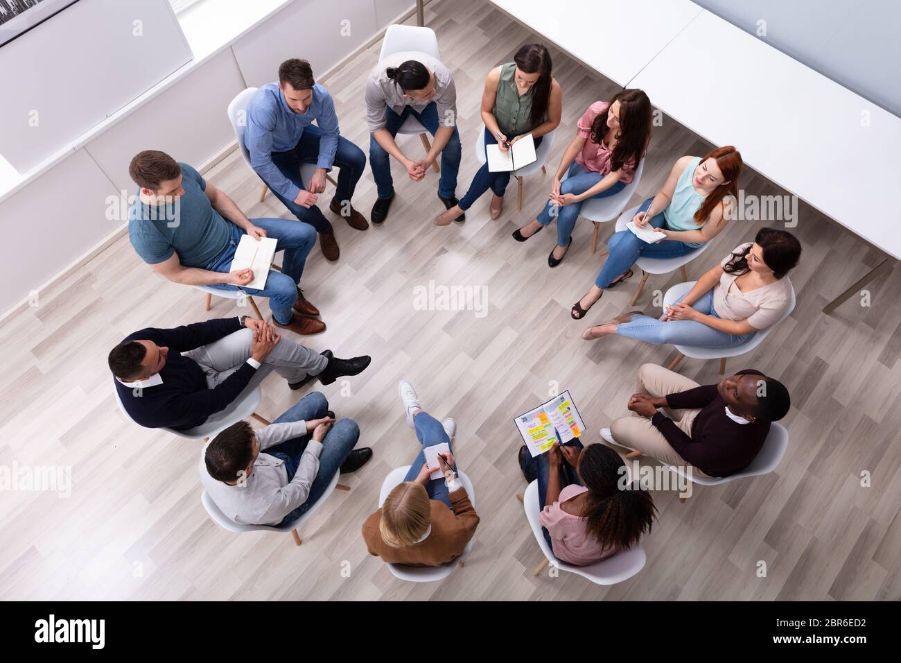 Elevato angolo di visione dei giovani e multirazziale amico millenario seduti in cerchio Counseling Foto Stock