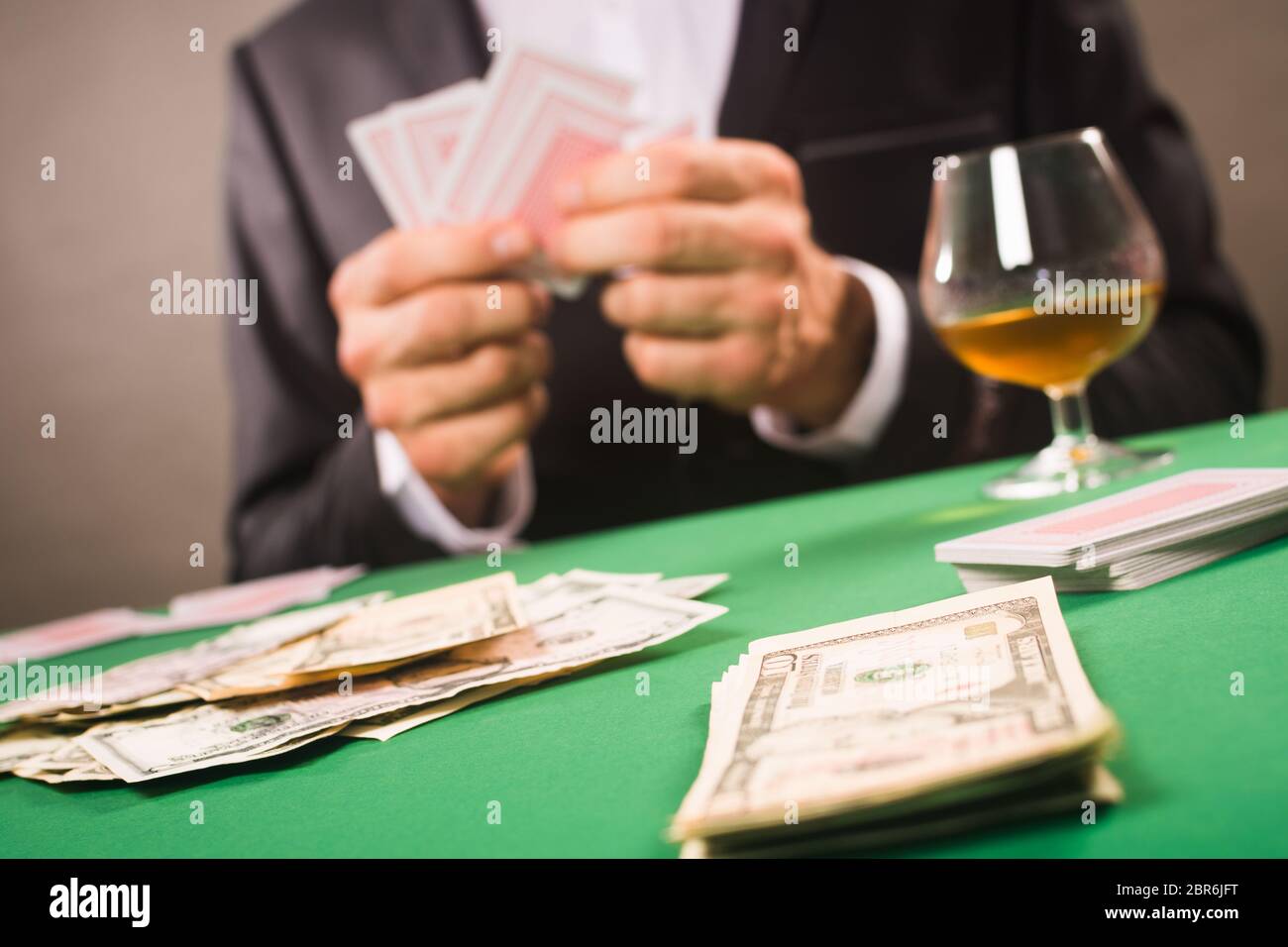 Il giocatore sta giocando a poker o altro gioco con carta da gioco per soldi, idea di gioco. Foto Stock