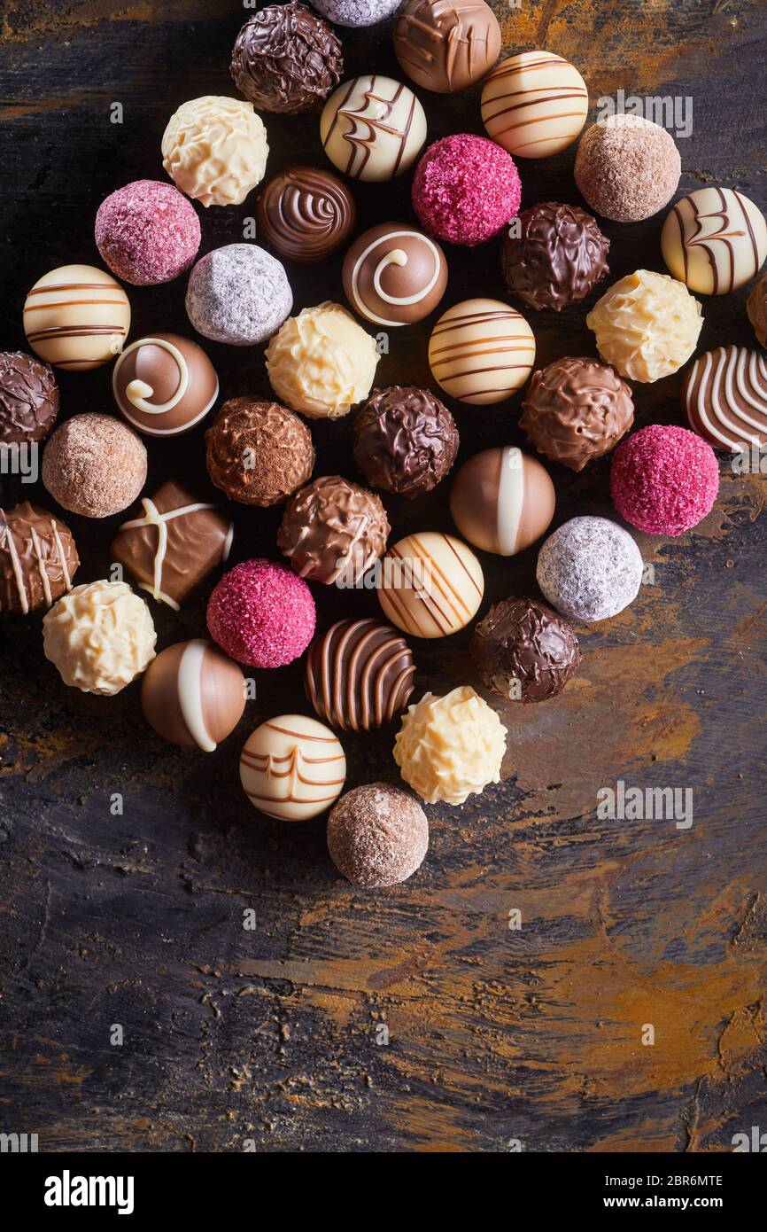 Ancora rettangolare vita di gourmet cioccolatini fatti a mano su una tavola in legno rustico visto dal di sopra con lo spazio di copia Foto Stock