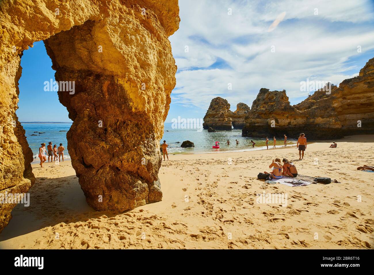 La gente si rilassa sulle spiagge di Lagos, Portogallo, dove spettacolari formazioni rocciose di arenaria si erigono dalle acque del Mar Mediterraneo Foto Stock