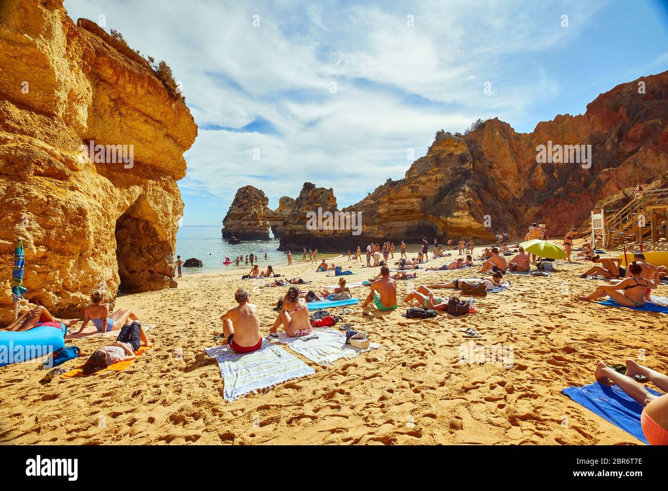 La gente si rilassa sulle spiagge di Lagos, Portogallo, dove spettacolari formazioni rocciose di arenaria si erigono dalle acque del Mar Mediterraneo Foto Stock